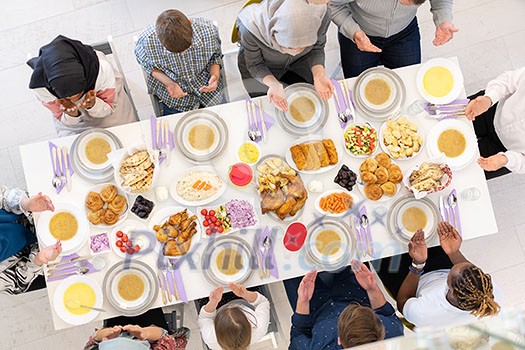 top view of modern multiethnic muslim family praying before having iftar dinner together during a ramadan feast at home top view of modern multiethnic muslim family praying before having iftar dinner together during a ramadan feast at home