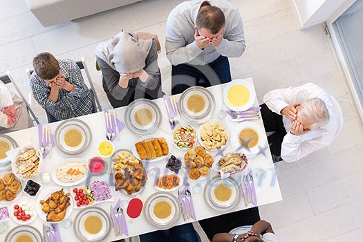 top view of modern multiethnic muslim family praying before having iftar dinner together during a ramadan feast at home top view of modern multiethnic muslim family praying before having iftar dinner together during a ramadan feast at home