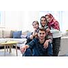 portrait of young happy modern muslim family before iftar dinner during ramadan feast at home