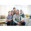 portrait of young happy modern muslim family before iftar dinner during ramadan feast at home