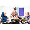 modern muslim family grandparents with grandchildren reading Quran and praying together on the sofa before iftar dinner during a ramadan feast at home