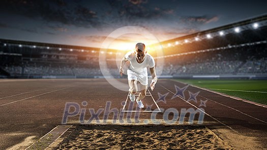 Athlete man running on racetrack at stadium. Mixed media Athlete man running on racetrack at stadium. Mixed media