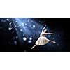 Elegant woman dancer in white dress against dark background