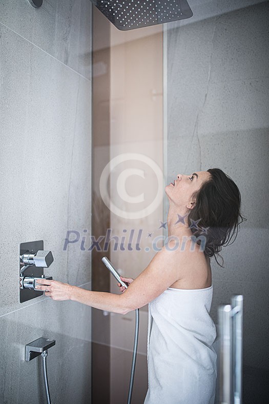 Woman taking a long hot shower washing her hair in a modern design bathroom Woman taking a long hot shower washing her hair in a modern design bathroom
