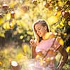 Cute girl picking apples in an orchard having fun harvesting the ripe fruits of her family's labour (color toned image)