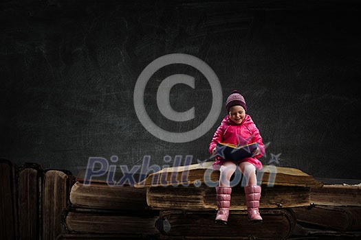 Happy child little girl reading book. Mixed media Happy child little girl reading book. Mixed media