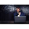 Handsome afroamerican businessman sitting at desk and working on laptop. Mixed media