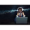 Handsome afroamerican businessman sitting at desk and working on laptop. Mixed media