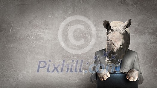Businessman with rhino head sitting with suitcase in hands. Mixed media Businessman with rhino head sitting with suitcase in hands. Mixed media