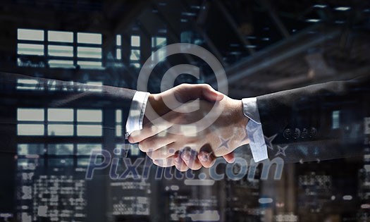 Close of business handshake in office interior. Mixed media Close of business handshake in office interior. Mixed media