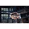 Close of business handshake in office interior. Mixed media