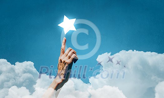 Human hand touching with finger star in sky Human hand touching with finger star in sky