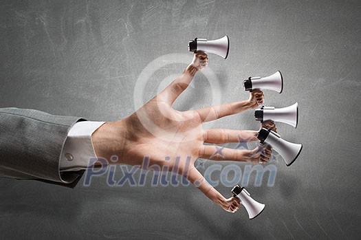 Close up of male hand and megaphones on each finger . Close up of male hand and megaphones on each finger .