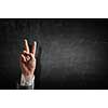 Close of businessman hand showing peace gesture .