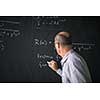 Math teacher drawing   fuction graph on a blackboard during mathclass (shallow DOF, color toned image)