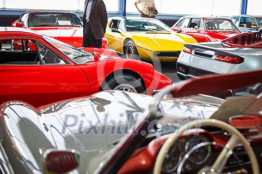 Old cars auction - People viewing cars on sale during an expensive old cars auction Old cars auction - People viewing cars on sale during an expensive old cars auction