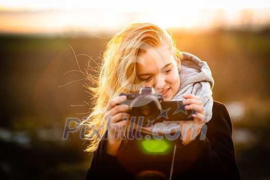 Cute female photographer with her dslr camera taking photos outdoor at sunset - photography taking concept (color toned image) Cute female photographer with her dslr camera taking photos outdoor at sunset - photography taking concept (color toned image)