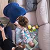 family, technology and people concept -top view of happy mother and father taking picture of baby boy with smartphone on the sofa at home
