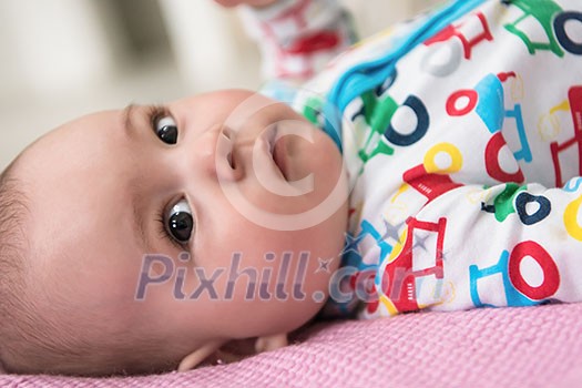 happy beautiful newborn baby boy lying on colorful blankets while playing first games at home happy beautiful newborn baby boy lying on colorful blankets while playing first games at home