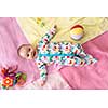 top view of happy beautiful newborn baby boy lying on colorful blankets while playing first games at home
