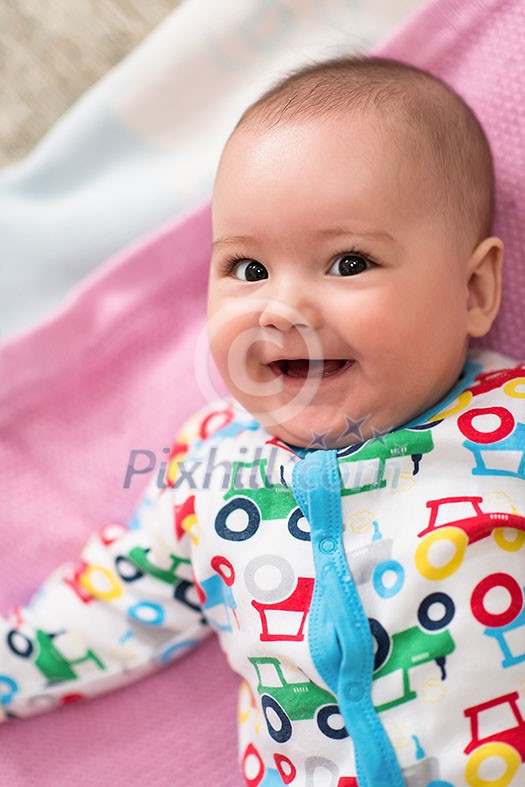 top view of happy beautiful newborn baby boy lying on colorful blankets while playing first games at home top view of happy beautiful newborn baby boy lying on colorful blankets while playing first games at home