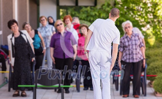 trainer training motivated active healthy senior people to performing exercise in the park trainer training motivated active healthy senior people to performing exercise in the park