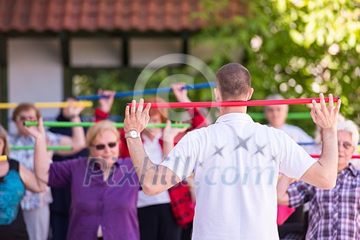 trainer training motivated active healthy senior people to performing exercise in the park trainer training motivated active healthy senior people to performing exercise in the park