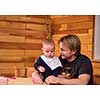 Father and son happy moments  Portrait of young father and his cute baby son playing together on table while spending time together at home