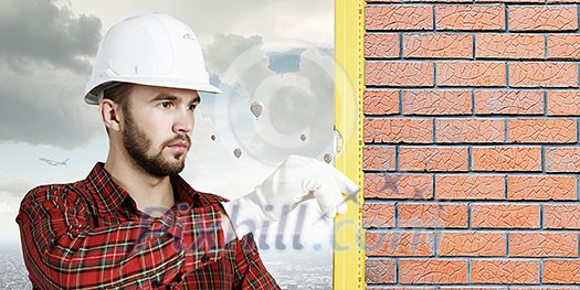 Builder man in checked shirt using measuring level Builder man in checked shirt using measuring level