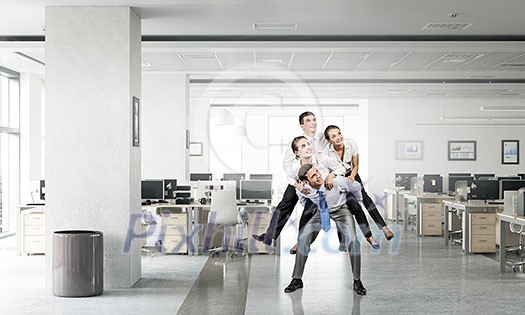 Businesswoman riding on back of her colleague in modern office Businesswoman riding on back of her colleague in modern office