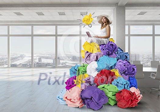 Young attractive girl writer with laptop and heap of crumpled paper Young attractive girl writer with laptop and heap of crumpled paper