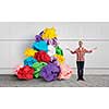 Young man in modern interior and paper balls as symbol of creativity