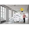Young man in modern interior and paper balls as symbol of creativity