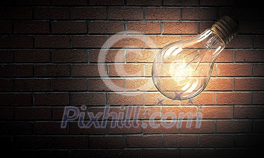 Power and energy concept with glass light bulb on brick wall Power and energy concept with glass light bulb on brick wall