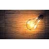 Power and energy concept with light bulb on wooden surface