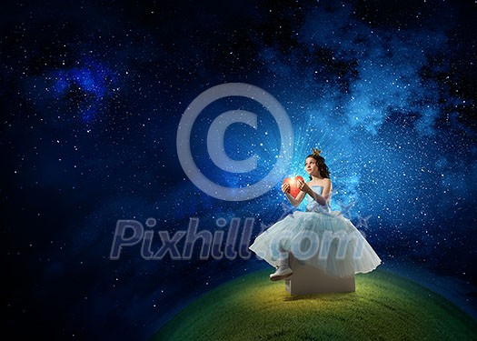 Little girl princess in blue dress with diadem on head and red heart in hands Little girl princess in blue dress with diadem on head and red heart in hands