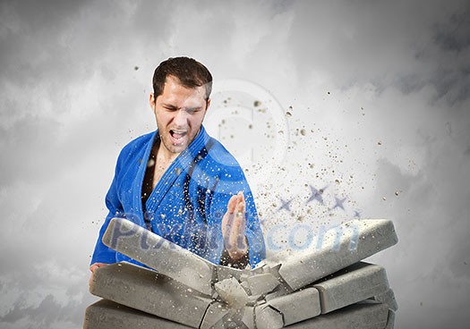 Determined karate man break with hand stone bricks Determined karate man break with hand stone bricks