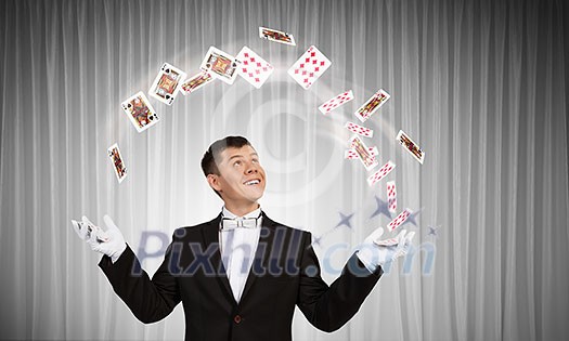Young cheerful businessman making tricks with magic hat Young cheerful businessman making tricks with magic hat
