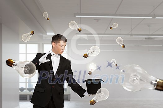 Young cheerful businessman making tricks with magic hat Young cheerful businessman making tricks with magic hat
