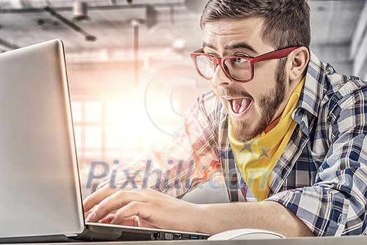 Young emotional guy in red glasses surfing the Internet Young emotional guy in red glasses surfing the Internet