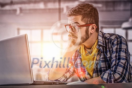 Young pensive guy in red glasses surfing the Internet Young pensive guy in red glasses surfing the Internet