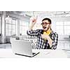 Young emotional guy in red glasses surfing the Internet
