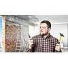 Casual man in checked shirt indoors with hammer and nails