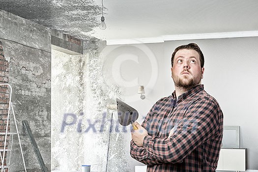 Man in checked shirt indoors with spatula in hand Man in checked shirt indoors with spatula in hand