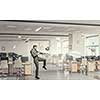 Businessman in suit in modern office jumping to hit soccer ball