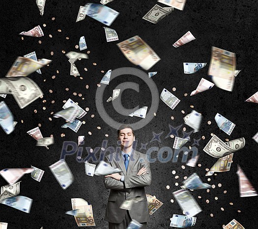 Young businessman standing in the rain of money banknotes Young businessman standing in the rain of money banknotes
