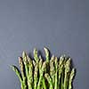 Fresh raw asparagus for cooking vegetarian food on a gray background with copy space. Top view. Vegan healthy nutrition concept.