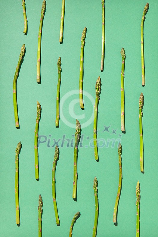 Food background with natural organic asparagus on a pastel green. Flat lay vegetables pattern. Vegan food concept. Food background with natural organic asparagus on a pastel green. Flat lay vegetables pattern. Vegan food concept.
