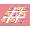 Colorful gerbera flowers on the lines of hashtag symbol on a pastel pink paper background with copy space. Greeting postcard