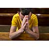 Handsome young man praying in a church